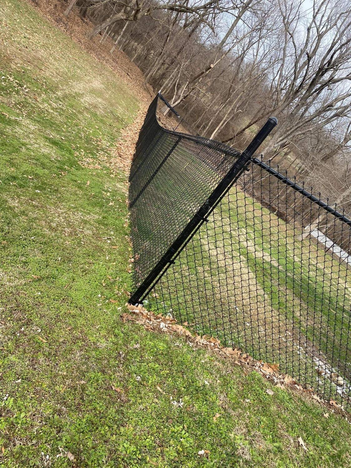 Black chain link following a wooded slope.