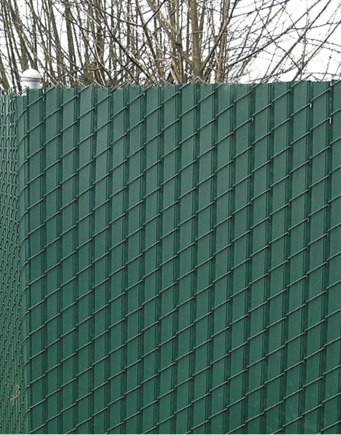 Green privacy slats woven through chain link to make a solid screen.