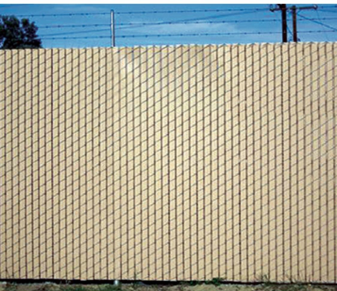 Tan privacy slat fence with a solid, uniform face.