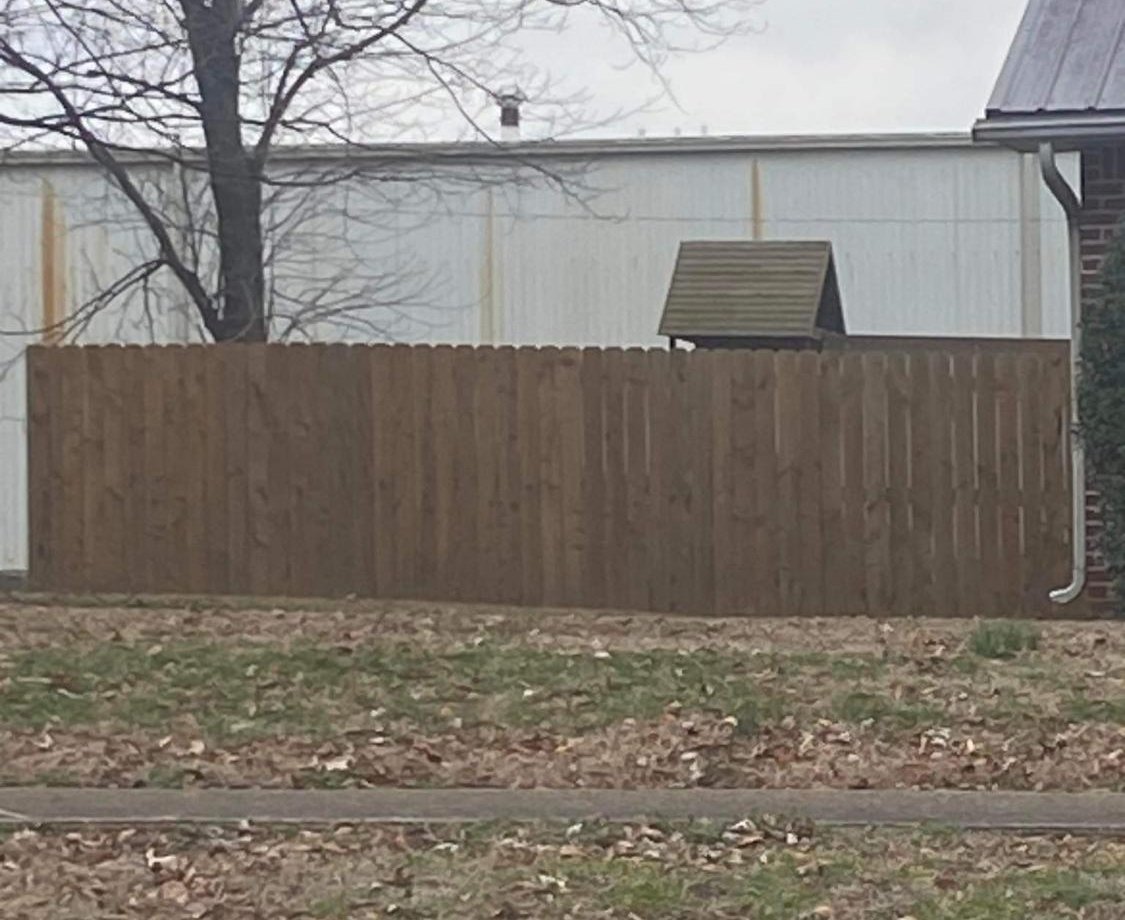 Stained wood privacy fence along a residential property line.